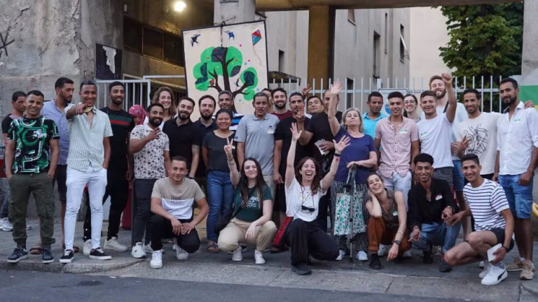 Un gruppo di persone di diverse etnie, uomi e donne, sono felici di essere parte di una comunità